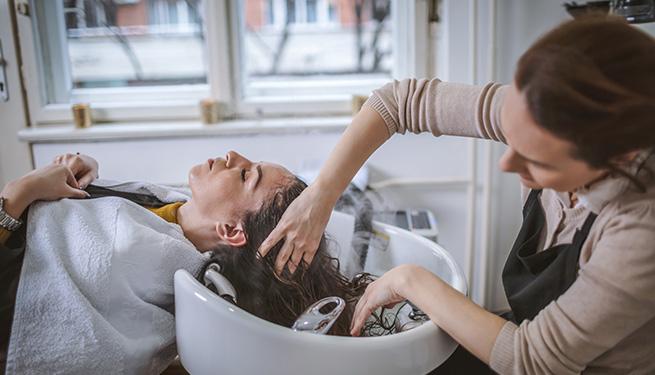 Hairdresser washing client's hair