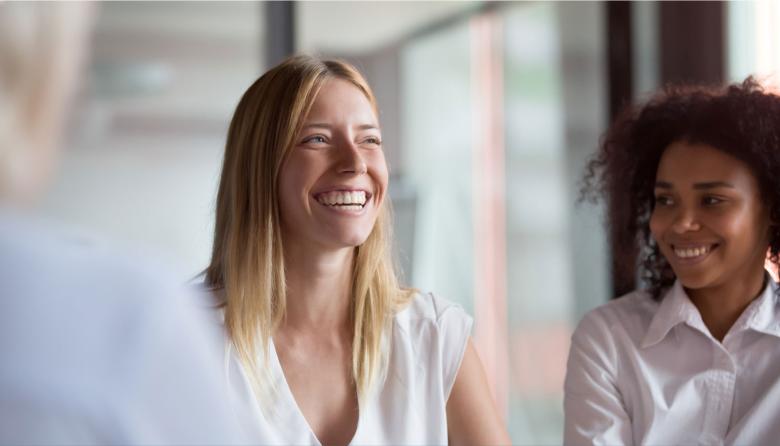 Two women in an office environment smiling